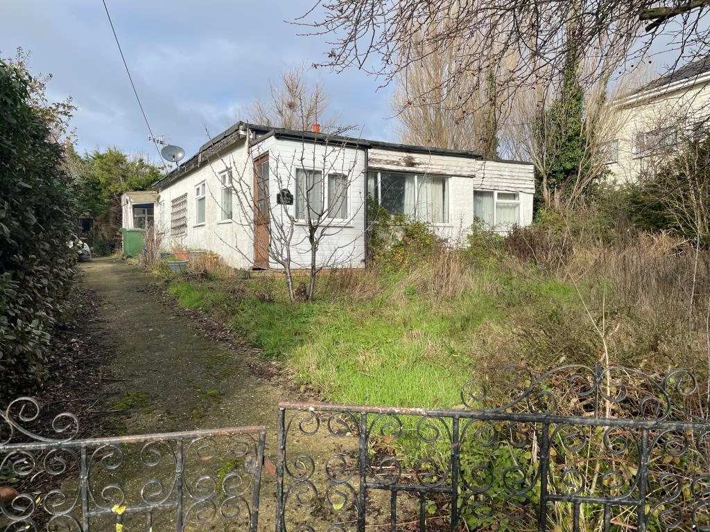 Lot: 118 - DILAPIDATED BUNGALOW ON GOOD SIZE PLOT - View from Road looking towards Bungalow